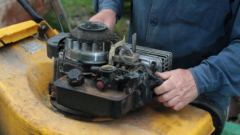 An old lawn mower engine in need of repair.