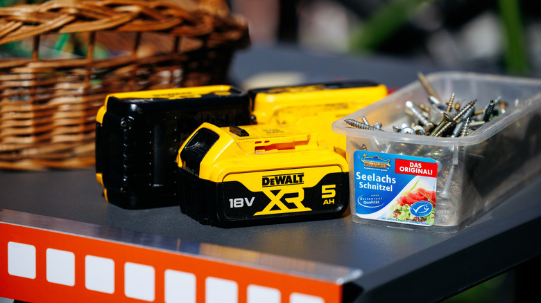 DeWalt batteries beside a box of screws.
