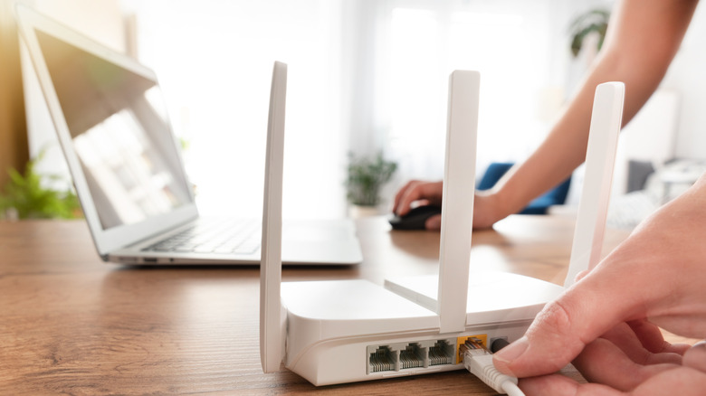 a close up of a Wi-Fi wouter near a laptop