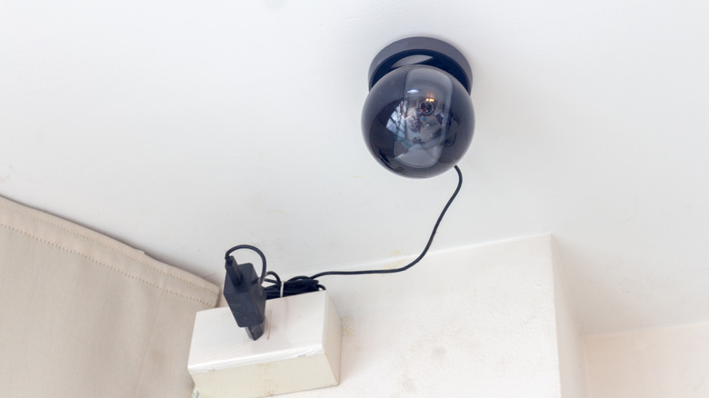 A black security camera connected to a power source