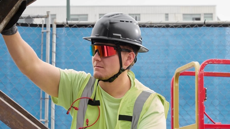 Worker at construction site wearing Milwaukee's wrap around mirrored safety glasses.