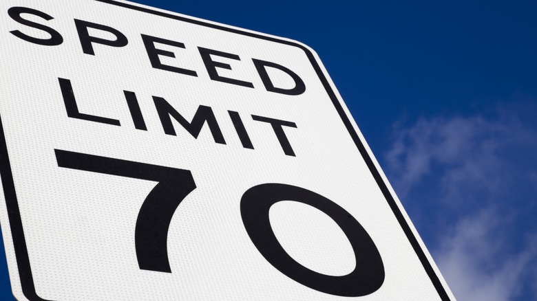 Close-up of a 70-mph speed limit sign against a dark blue sky