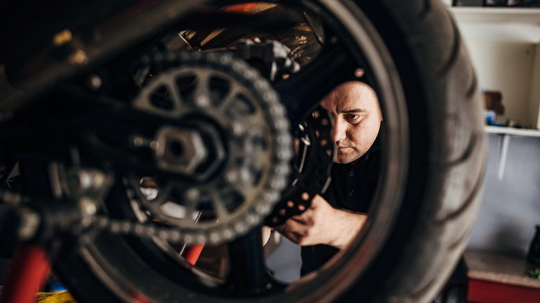 A motorbike mechanic working on a bike in a workshop