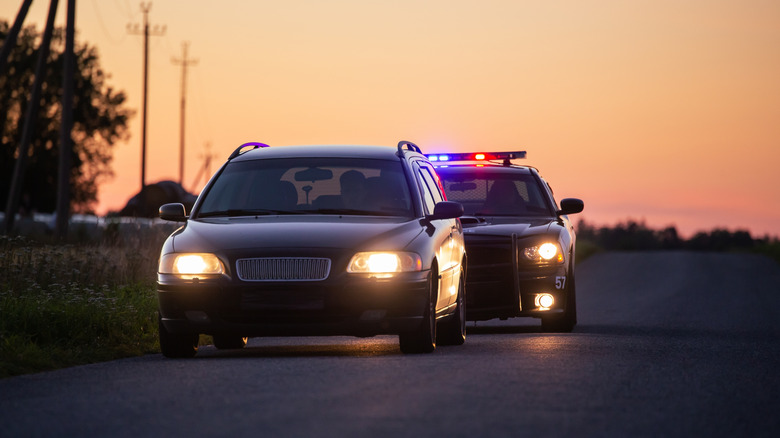 A car being pulled over by police at dusk