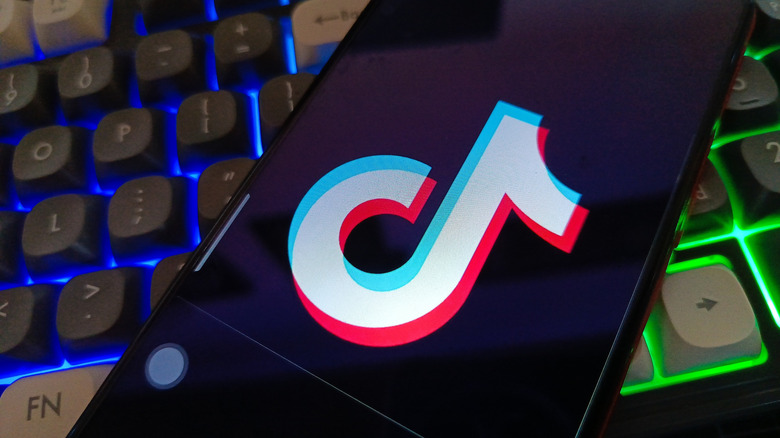 TikTok logo on a smartphone on top of a computer keyboard