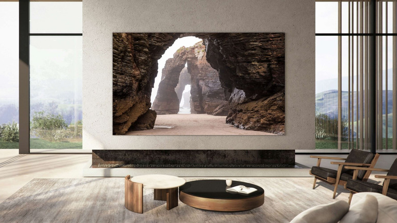 A minimalist room with a large flat screen Samsung TV hung on a wall showing a rocky wallpaper