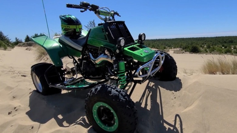 Customized green Yamaha Banshee 350 parked on sand dunes