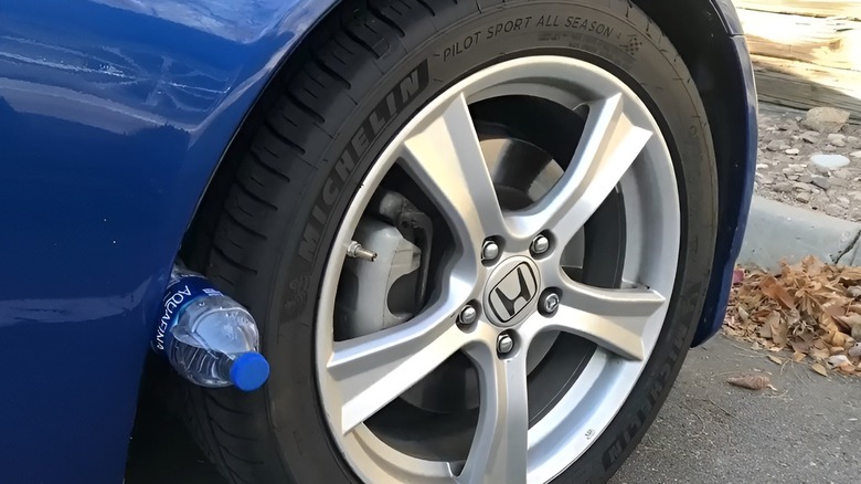 Aquafine water bottle lodged on car tire
