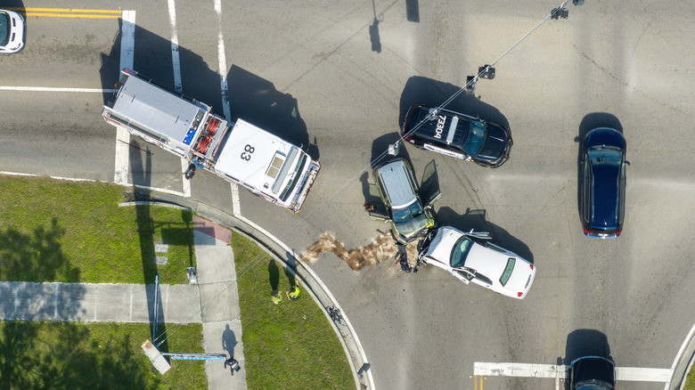 Aerial view of two cars colliding in intersection with firetruck on the scene