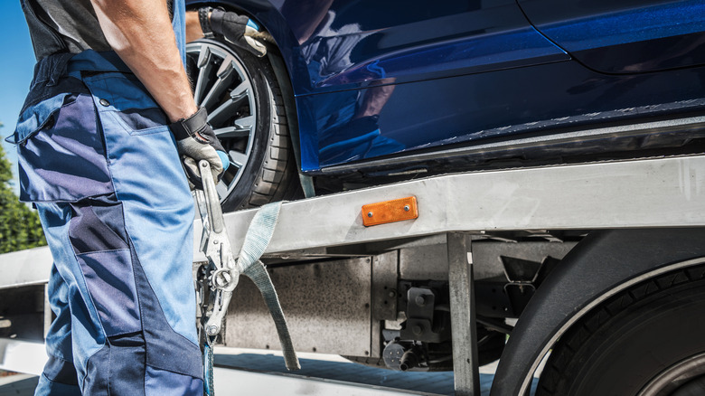 Car about to be towed on a tow truck bed