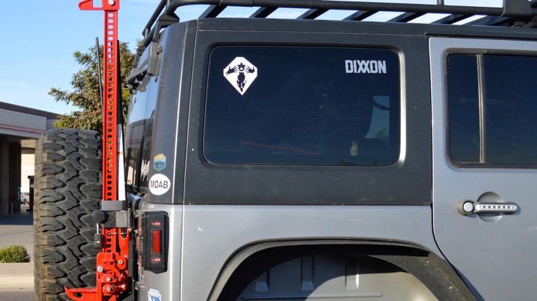 Off-road jack strapped to the back of a Jeep Wrangler