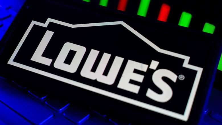 Lowes Hardware Brand Company Logo on Screen with Stock Chart Trends