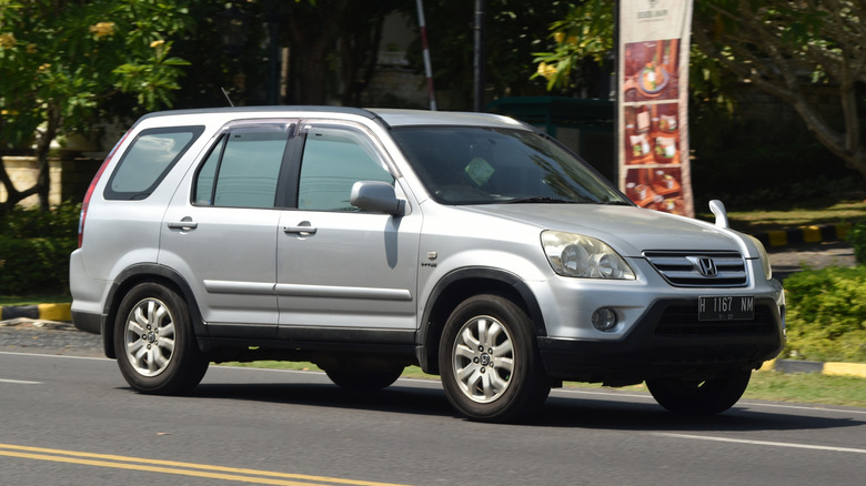 A first-generation Honda CR-V on the move, front 3/4 view, silver exterior