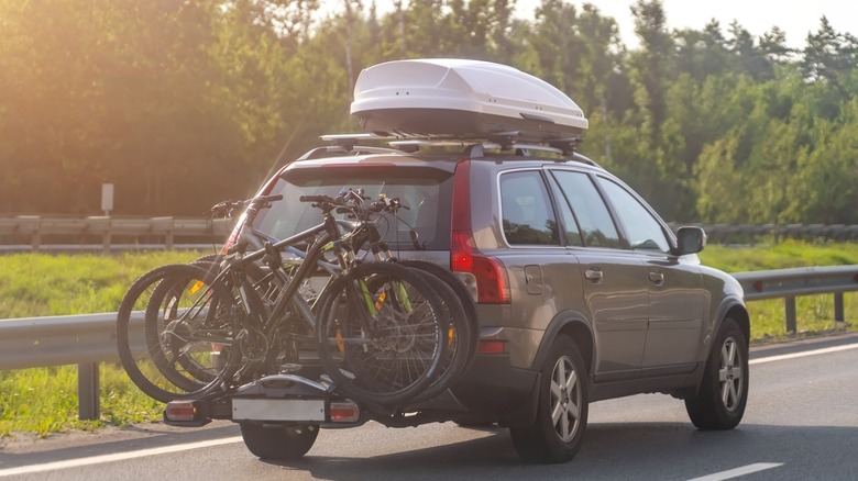 Car with bicycles mounted behind it and a roof rack above it