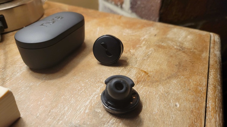 The NuraTrue Pro buds outside the case on a table