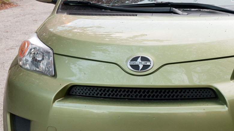 The front end of a light green Scion xD.