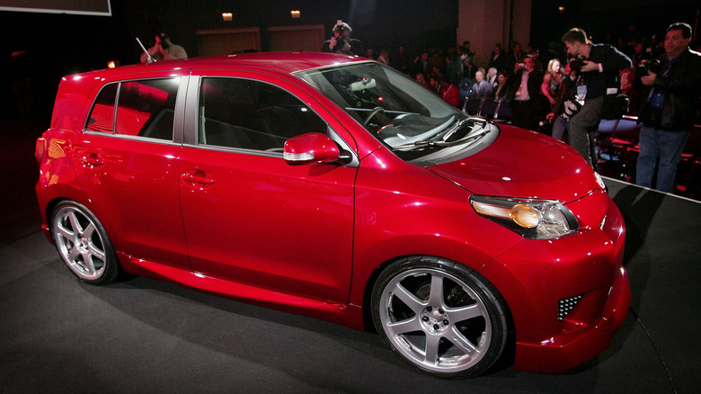 A red Scion xD on display at an auto show.