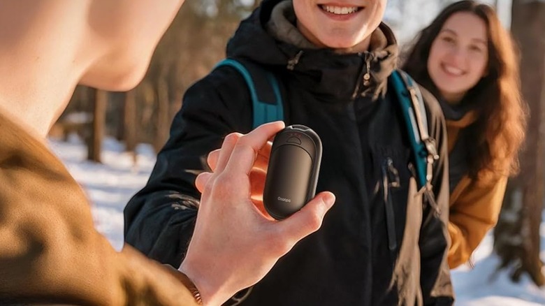 person handing over hand warmer