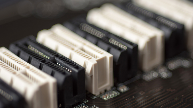 A close up shot of PCIe slots lined up in black and white.