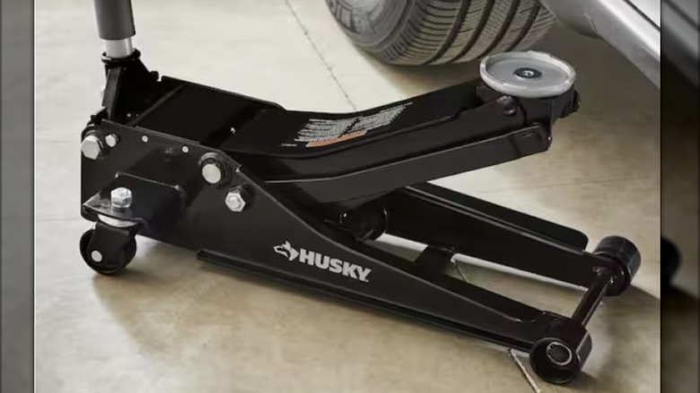 The Husky 3-ton Quick Lift Floor Jack from The Home Depot position next to car.