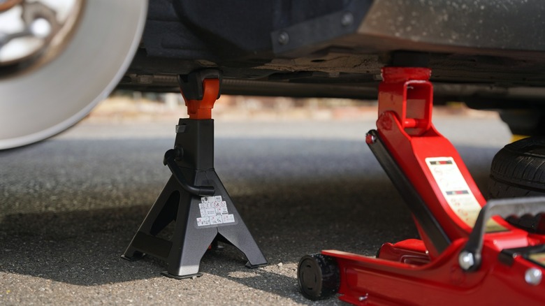 Using jack stands to support a vehicle after raising it with a floor jack.