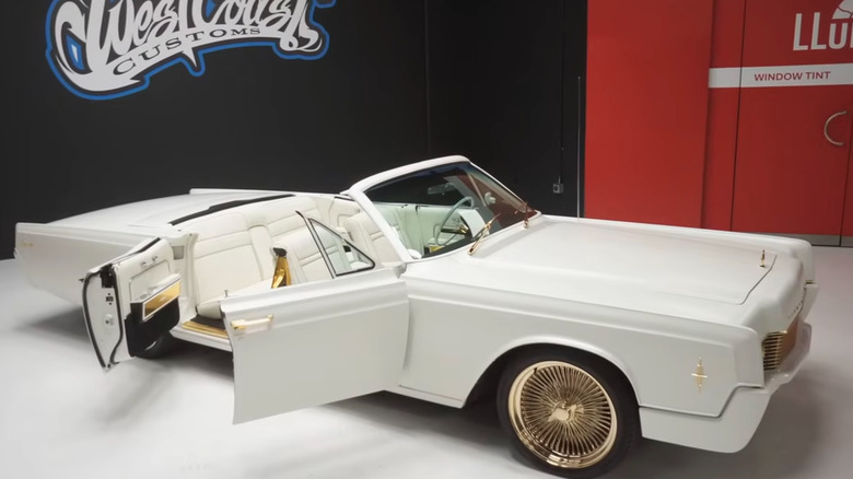 Custom 1966 Lincoln Continental parked on shop floor, front-right 3/4 low-angle view