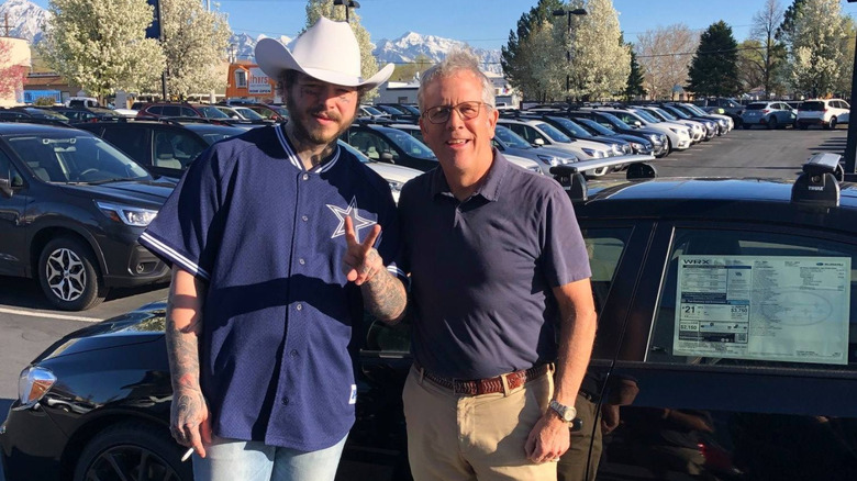 Post Malone at dealership posing with a fan in front of 2019 Subaru WRX with dealer window sticker in-place