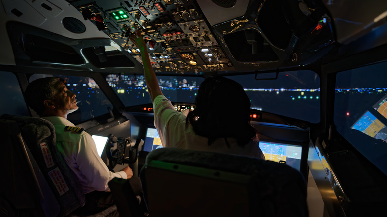 Two pilots in airliner cockpit at night
