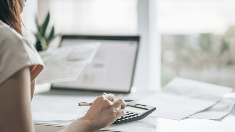 A person doing taxes with a calculator