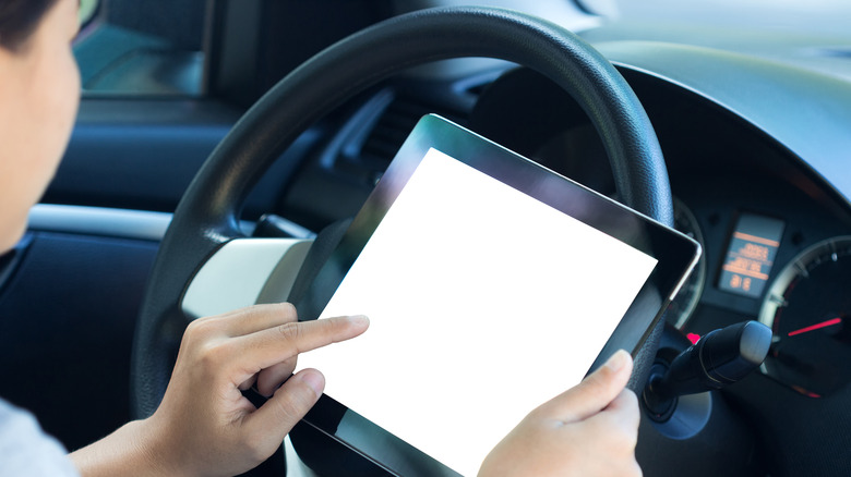 Woman using tablet in car