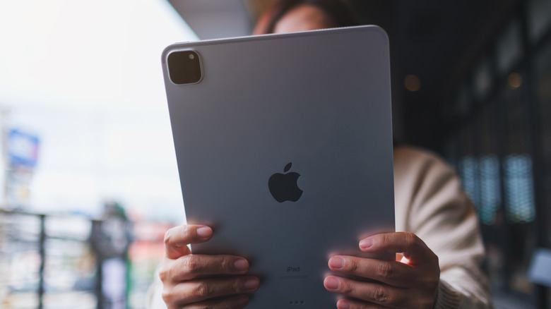 A woman holding and using an iPad