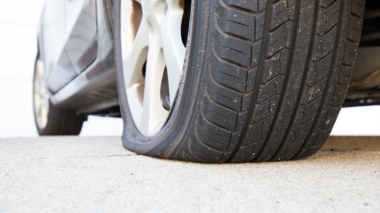 Closeup of a flat rear tire on a car