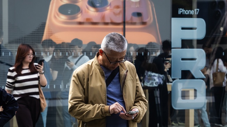 A man uses his smartphone outside an Apple Store