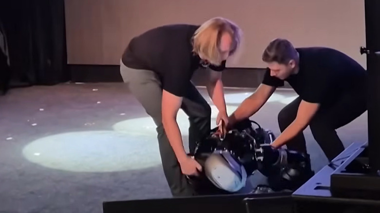 Handlers pick the AIDOL robot off the floor