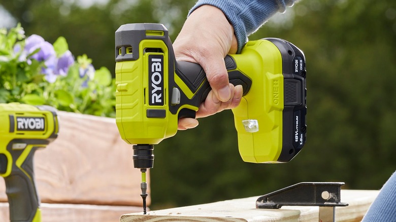 person using Ryobi impact driver