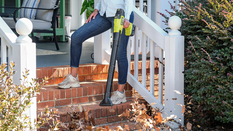 woman leaf blower porch