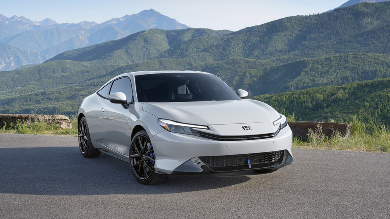 front right view of white Honda Prelude with mountains in background