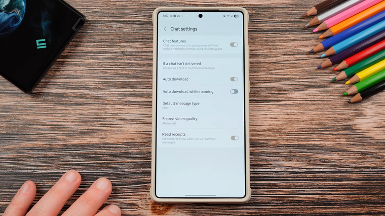 Samsung phone on a wooden desk showing chat settings