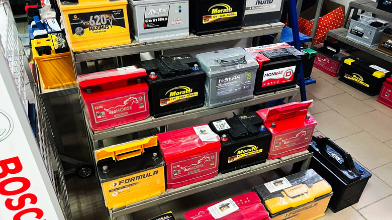 Car batteries stored on shelfs and the floor.