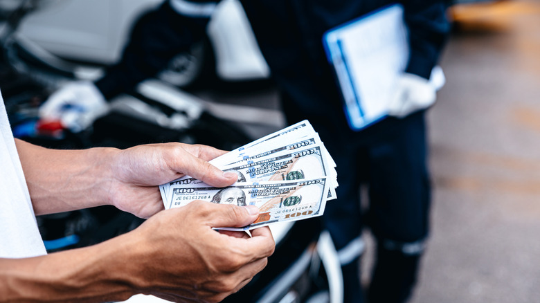 Car owner counting money to pay a mechanic