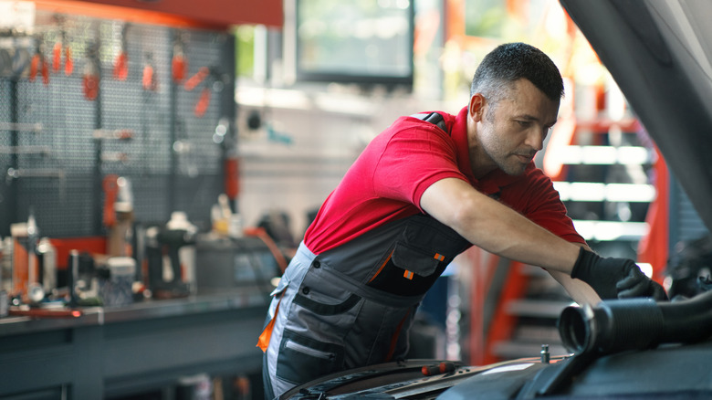 A mechanic working on a car's engine