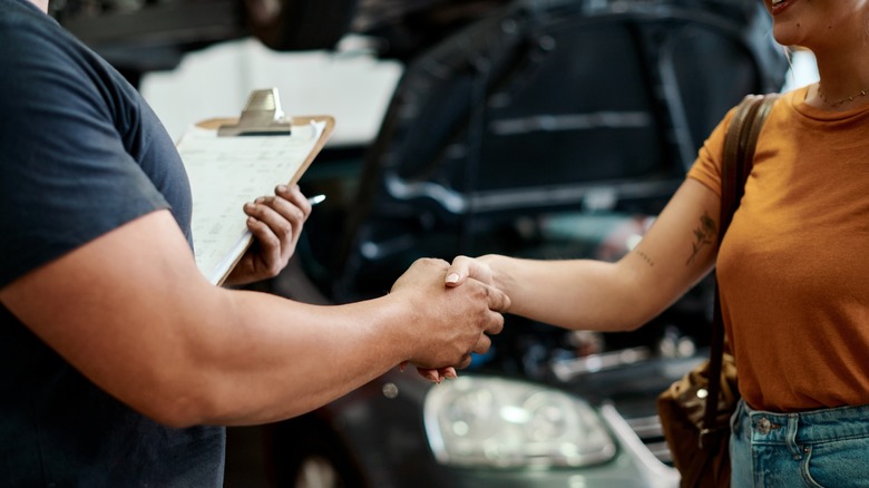 A mechanic and customer shaking hands