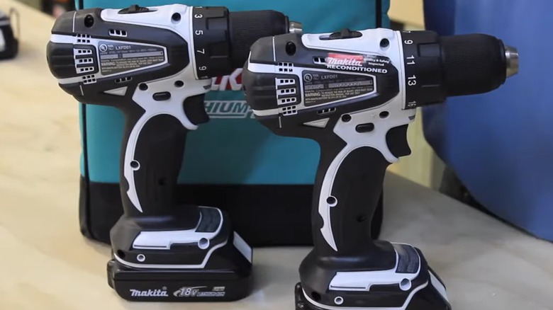 A new and a reconditioned Makita drill on a table.