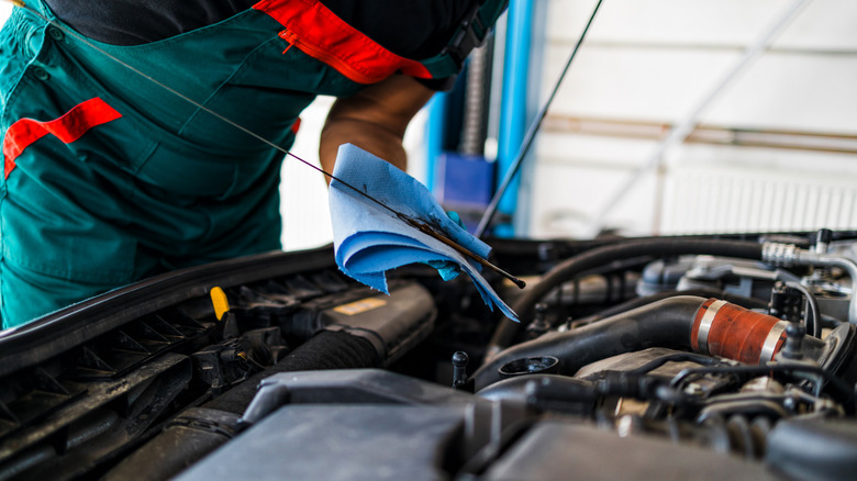 Mechanic checking oil dipstick