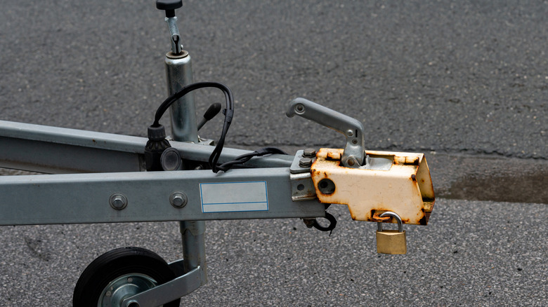 A trailer hitch on a paved surface.