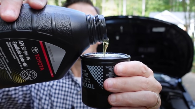 Prefilling an oil filter during an oil change.