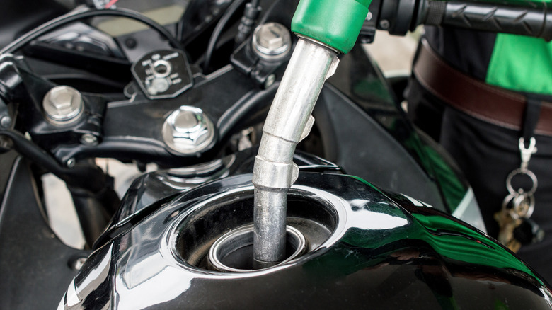 A person putting gas in a motorcycle