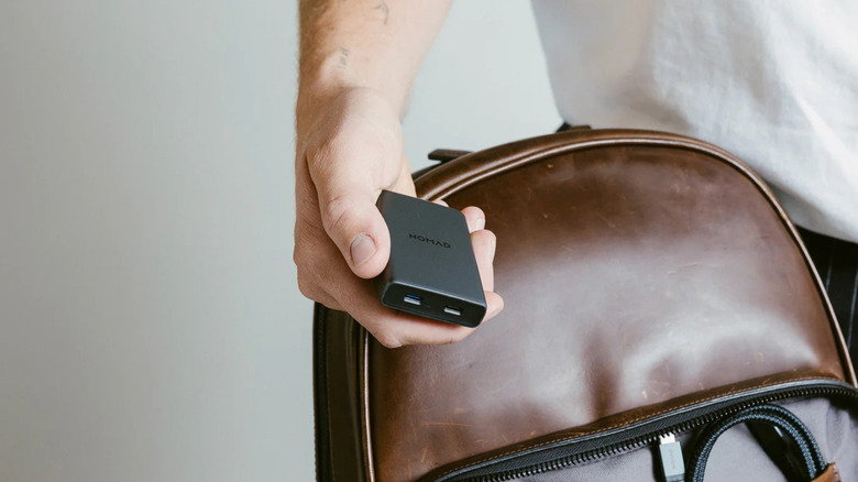 Hand holding Nomad Goods slim phone charger