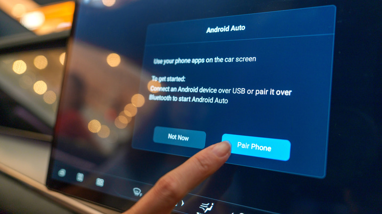 Close-up of a user interacting with the Android Auto pairing interface on the digital display inside a BYD electric car.