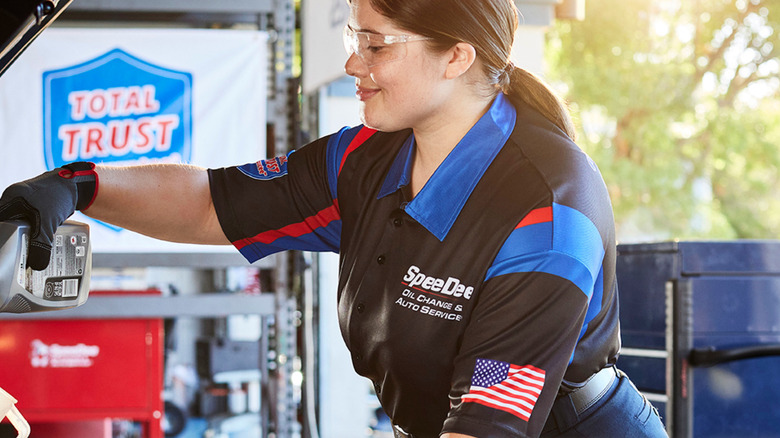 Spee Dee technician adding oil to engine
